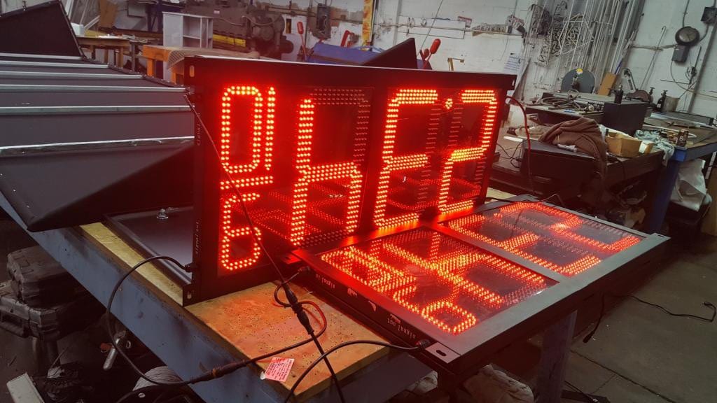 LED fuel price digit panels lit red on a workbench in the sign shop