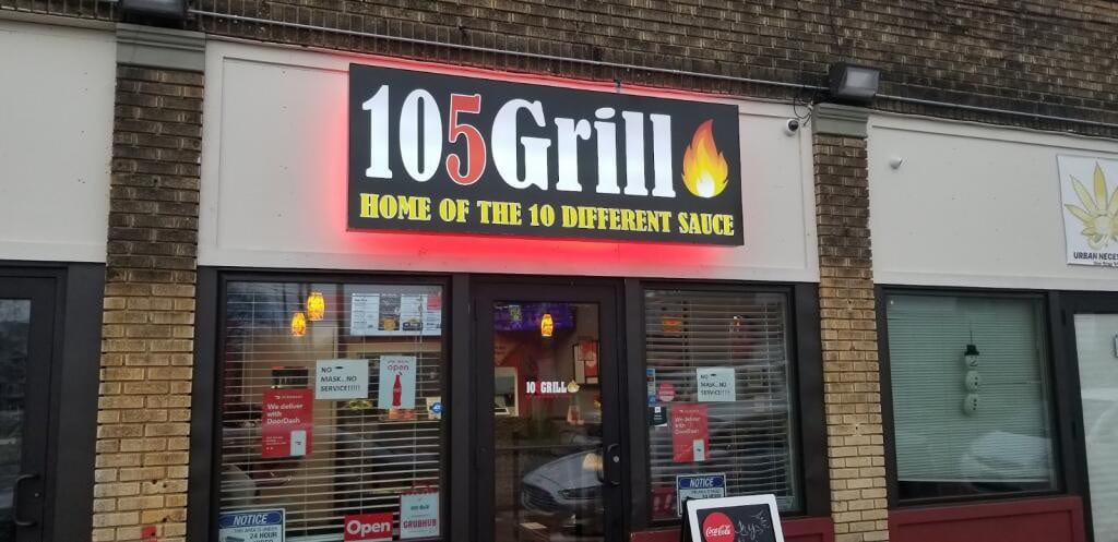 Illuminated 105 Grill sign with red halo glow above a storefront entrance