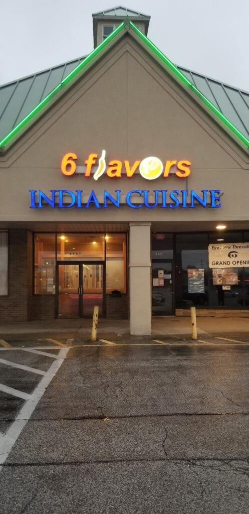 Lit 6 flavors Indian Cuisine channel letters with green LED roofline trim at dusk