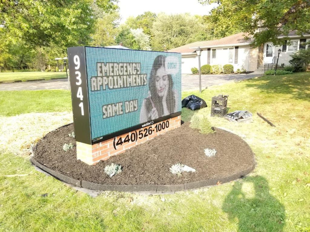 Brick-based monument sign with a full-color digital message display and phone number