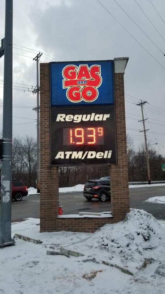 Gas and Go pylon sign with brick columns and an LED fuel price display above snow