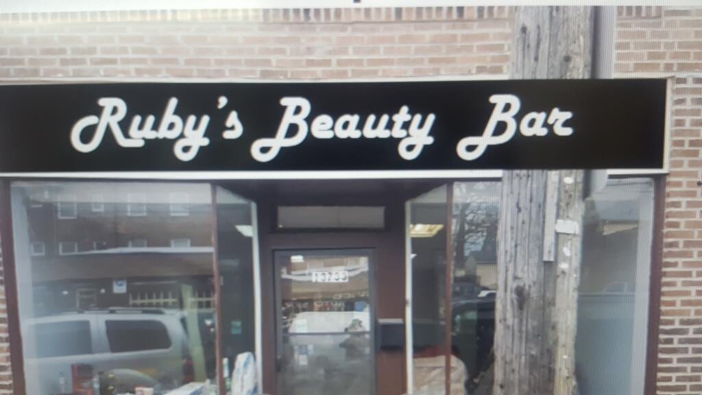 Ruby's Beauty Bar white script lettering on a black fascia panel above a brick storefront