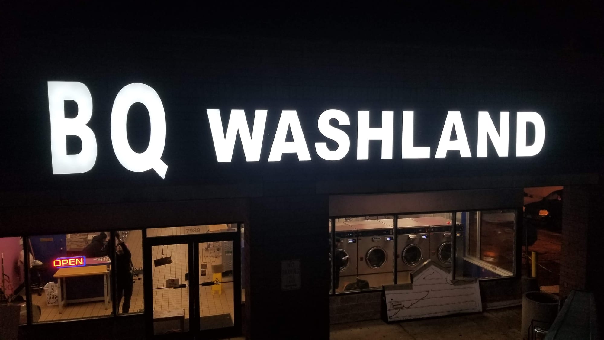 BQ WASHLAND white channel letters lit at night above a laundromat storefront