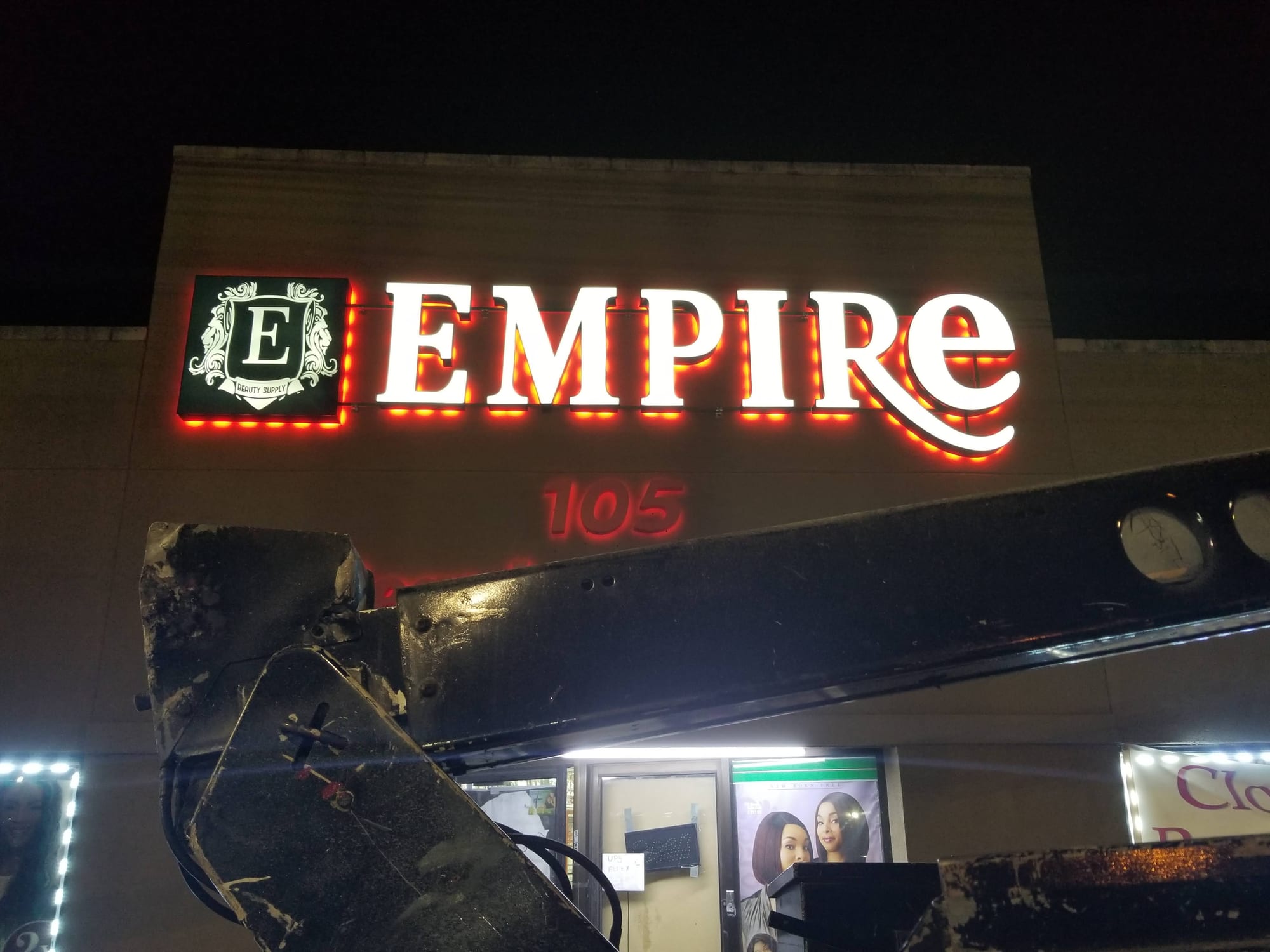 EMPIRE letters and logo cabinet glowing with red halo lighting at night