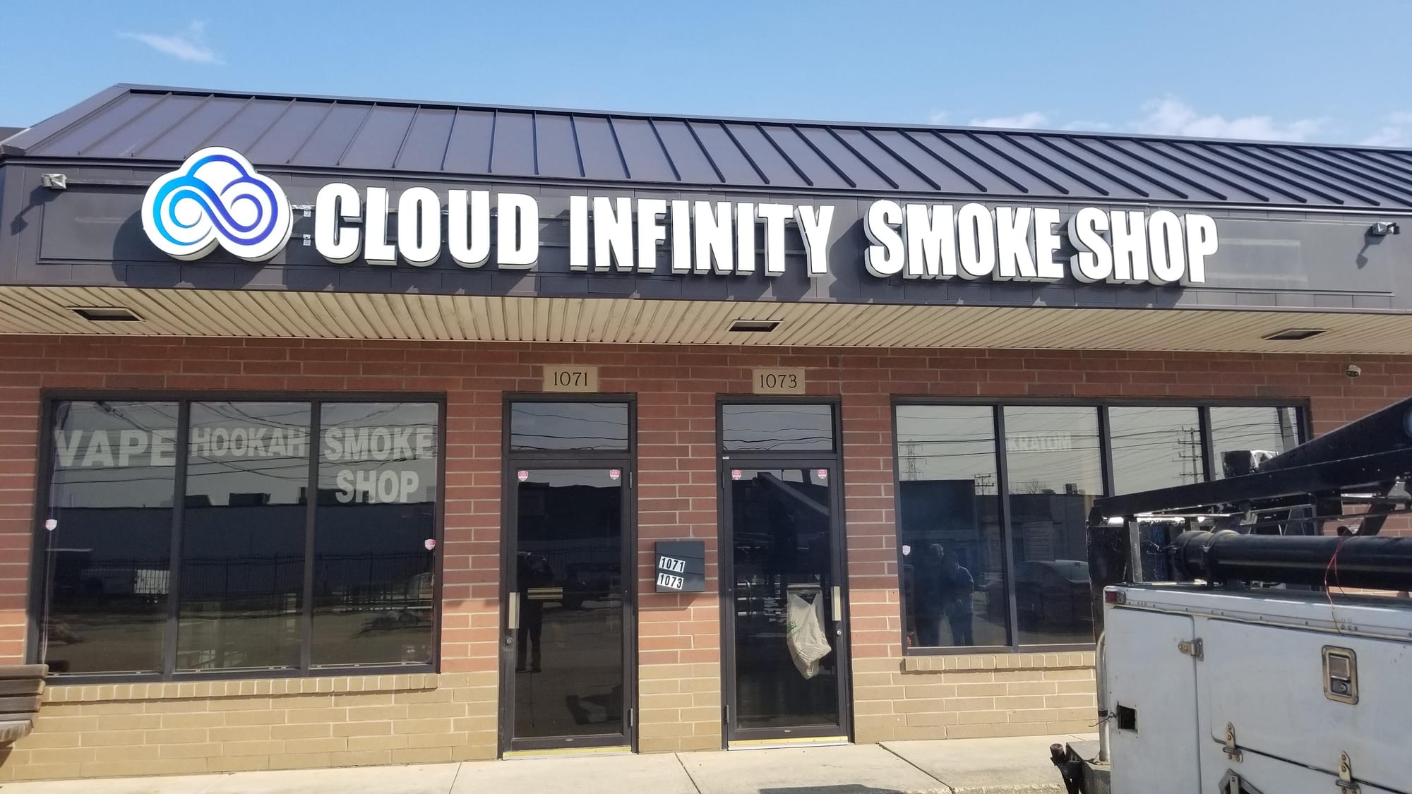 Cloud Infinity Smoke Shop channel letters and logo mounted on a storefront fascia