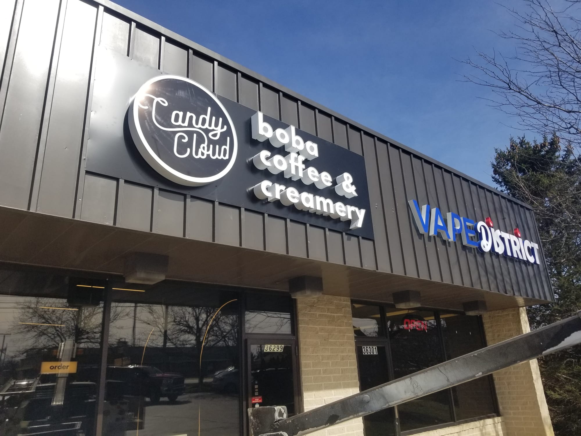 Candy Cloud logo cabinet and channel letters mounted on a storefront fascia