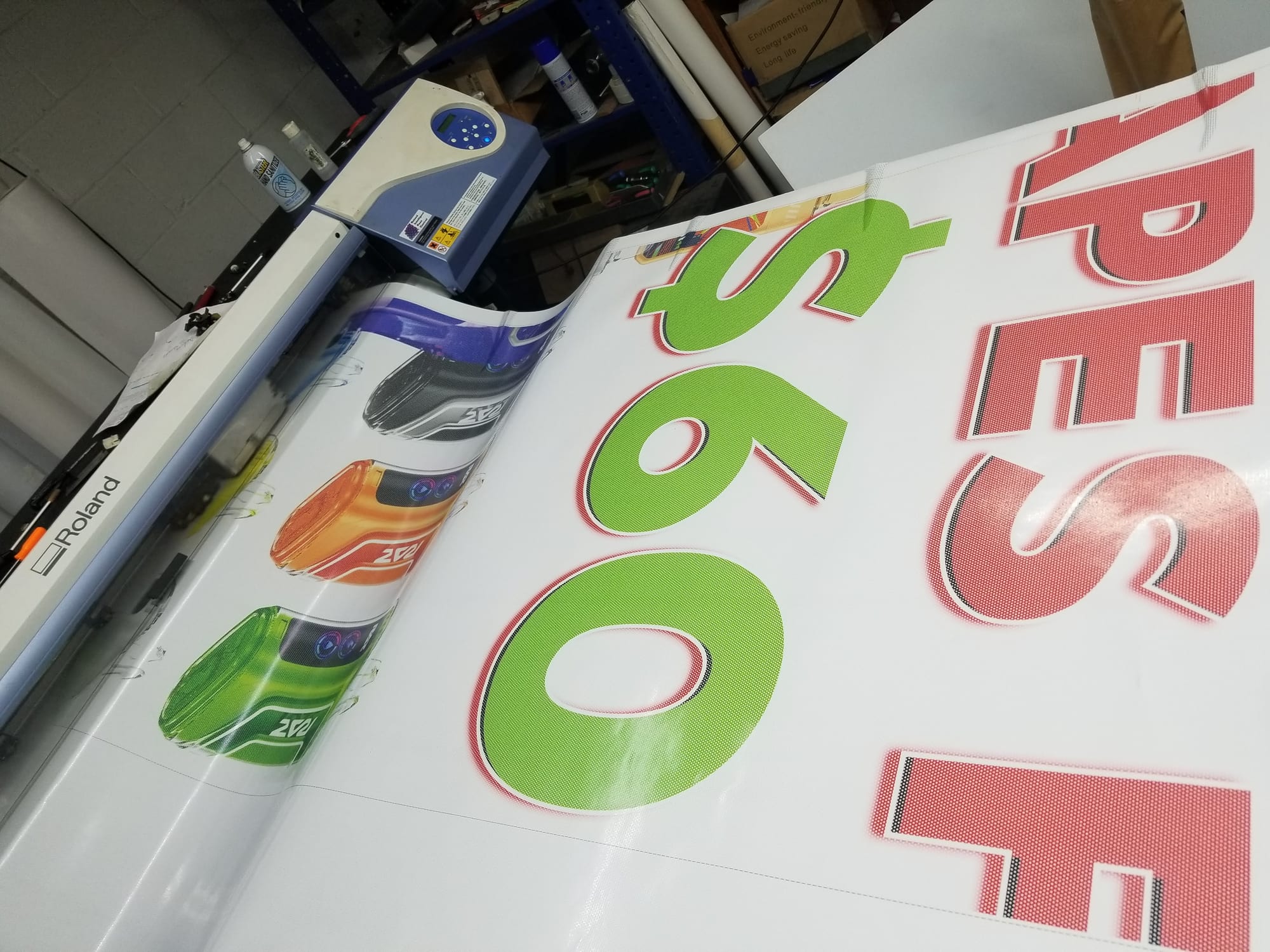 Printed vape banner coming off a Roland wide-format printer in the shop