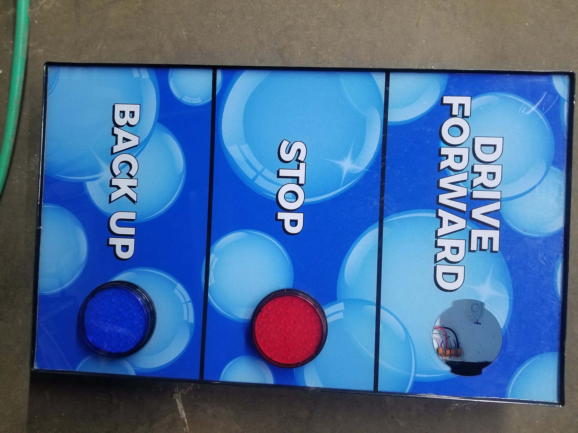 Blue illuminated cabinet sign reading DRIVE FORWARD, STOP and BACK UP with indicator lights