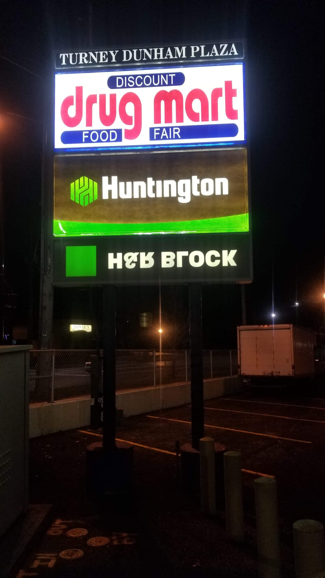 Lit Turney Dunham Plaza pylon sign with Discount Drug Mart, Huntington and H&R Block panels