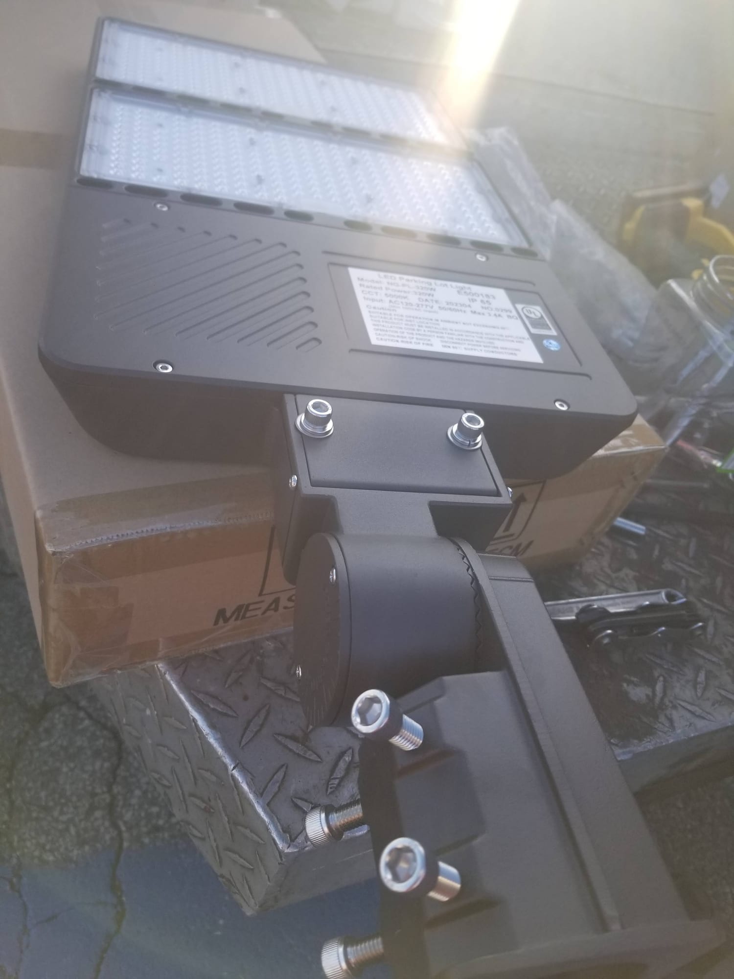 New LED parking lot light fixture resting on its shipping carton