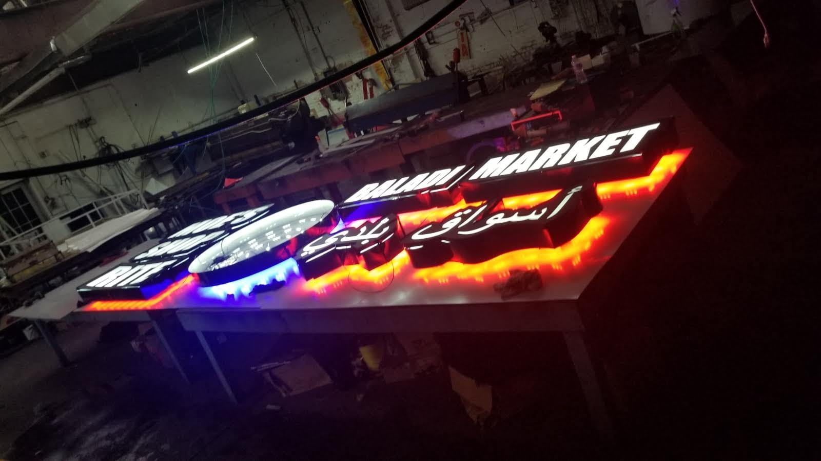 Illuminated BALADI MARKET letters with Arabic lettering lit on a shop table