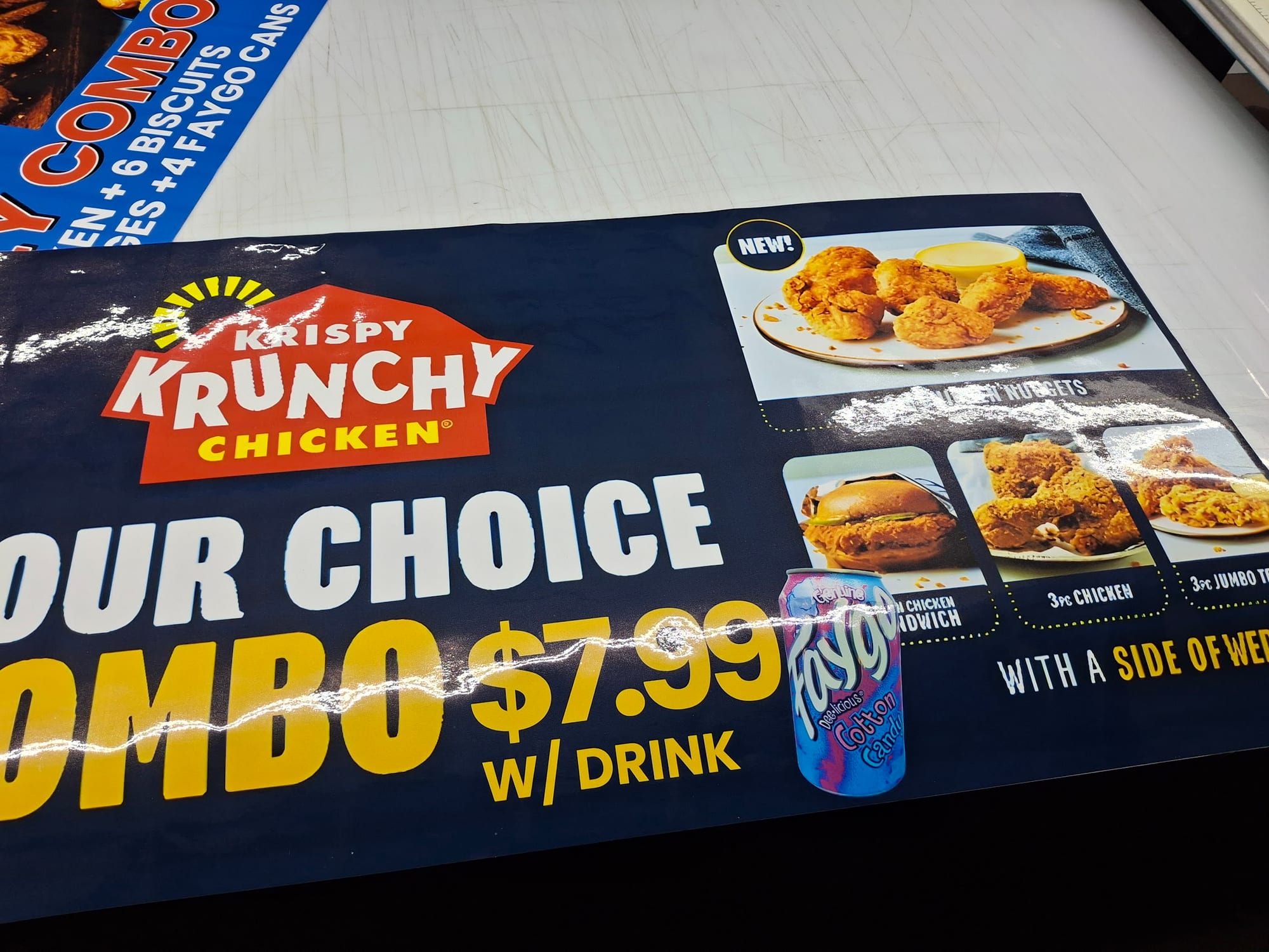 Printed Krispy Krunchy Chicken combo banner laid out on a shop table