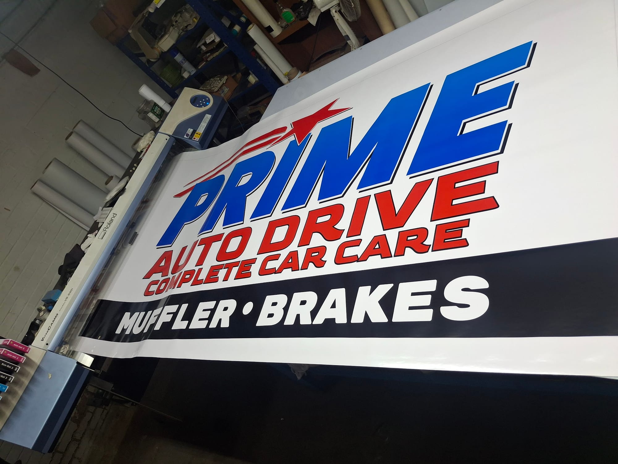 Printed Prime Auto Drive Complete Car Care banner on a Roland printer in the shop