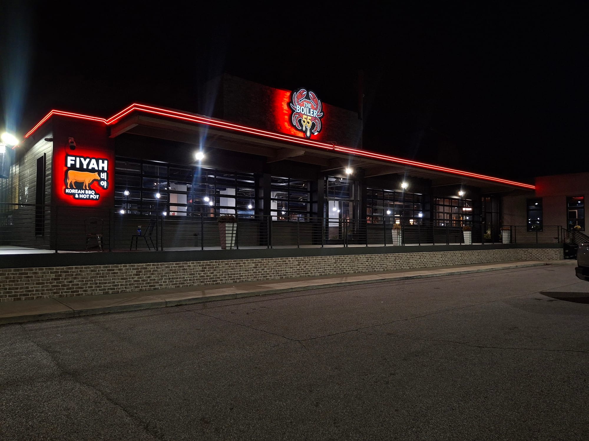 Lit FIYAH and The Boiler 55 cabinet signs with red LED roofline trim at night