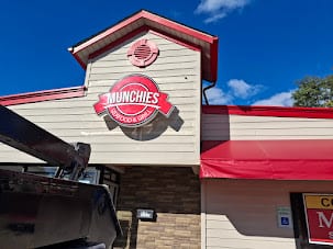 Munchies logo cabinet sign mounted on a gabled storefront facade