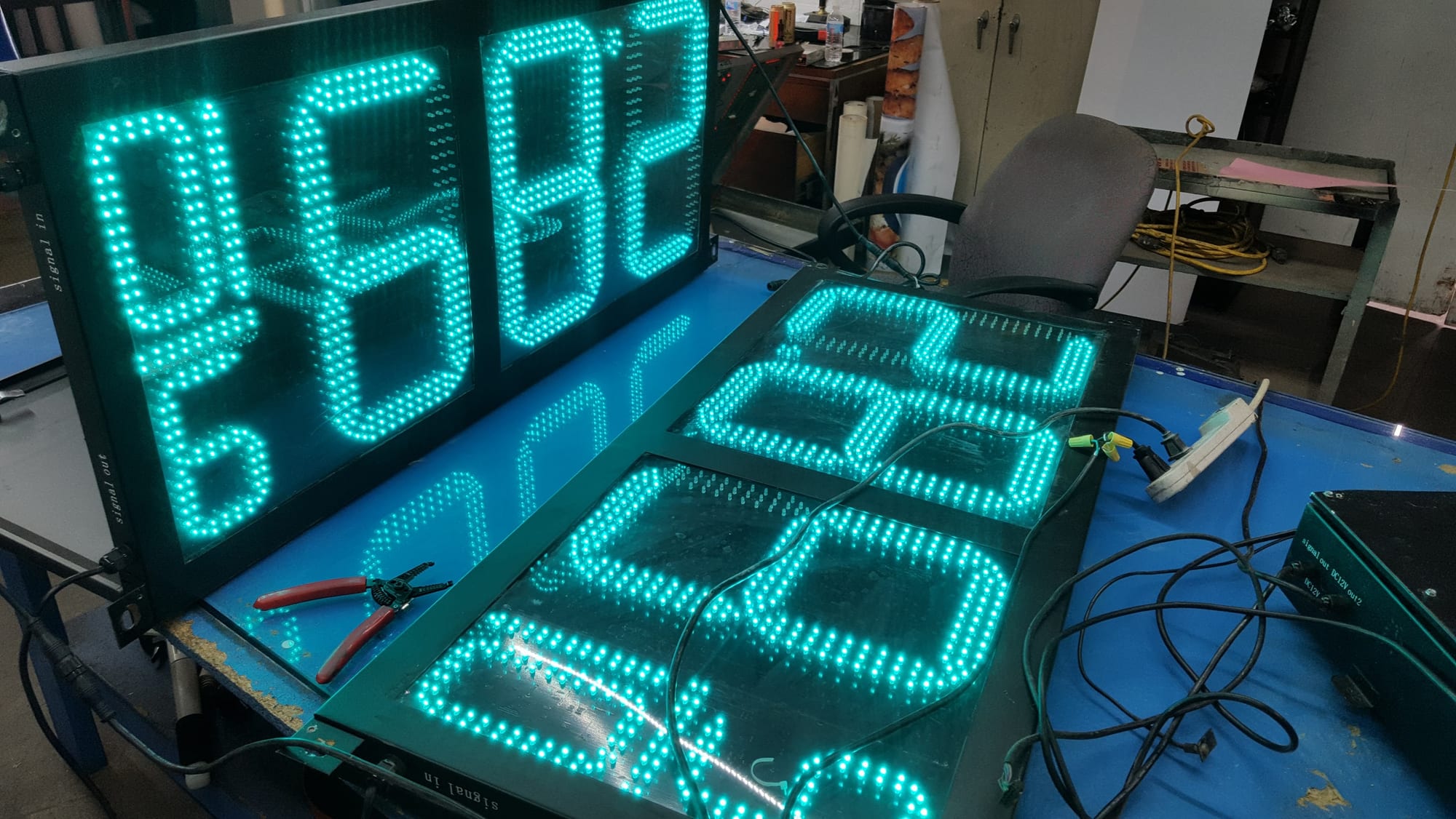 Green LED digit panels wired and lit on a shop table during testing