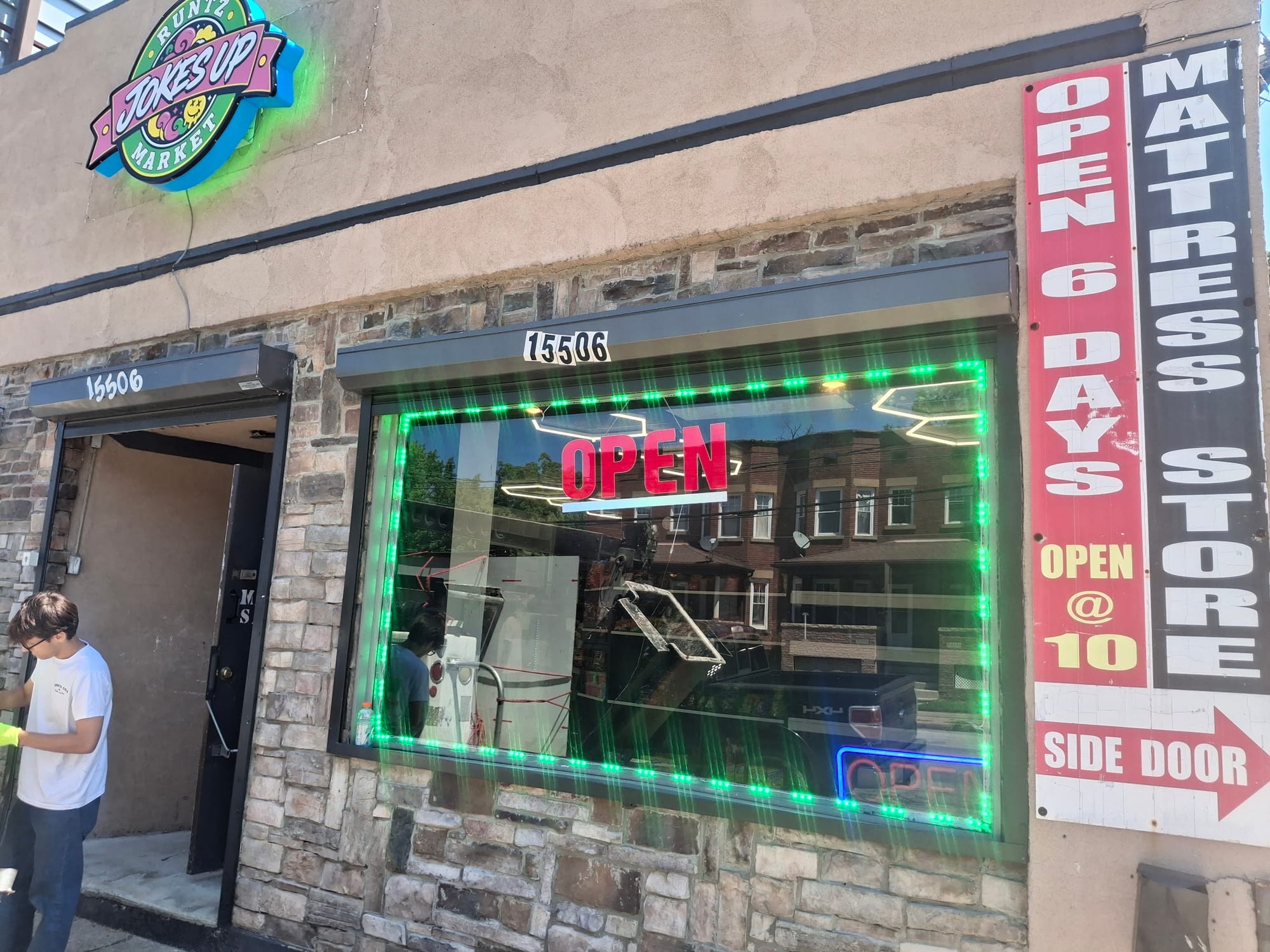 Jokes Up Runtz Market logo cabinet sign and green LED window trim on a storefront