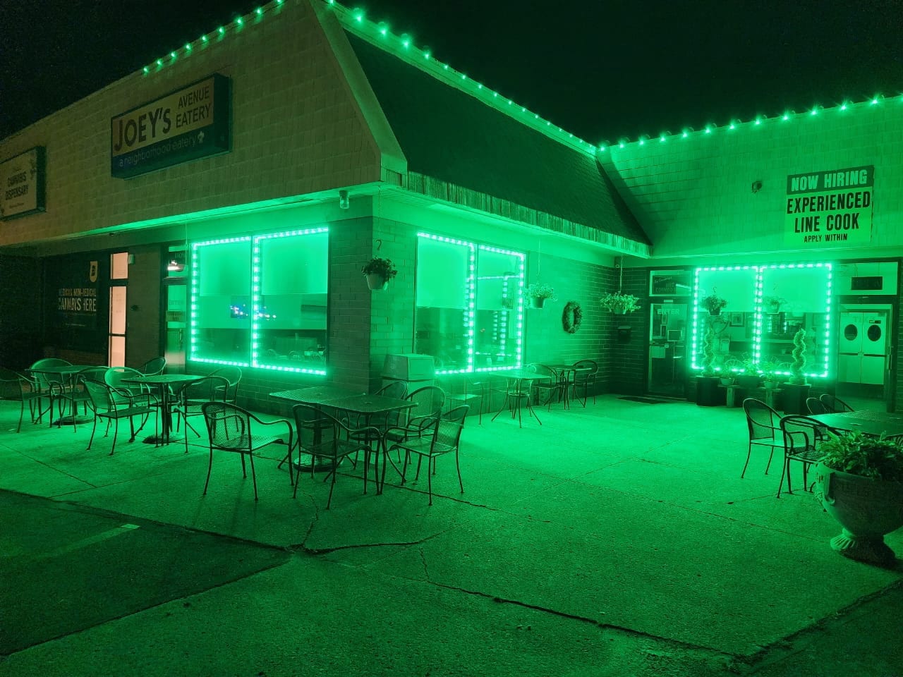 Green LED accent lighting outlining the windows and roofline at Joey's Avenue Eatery