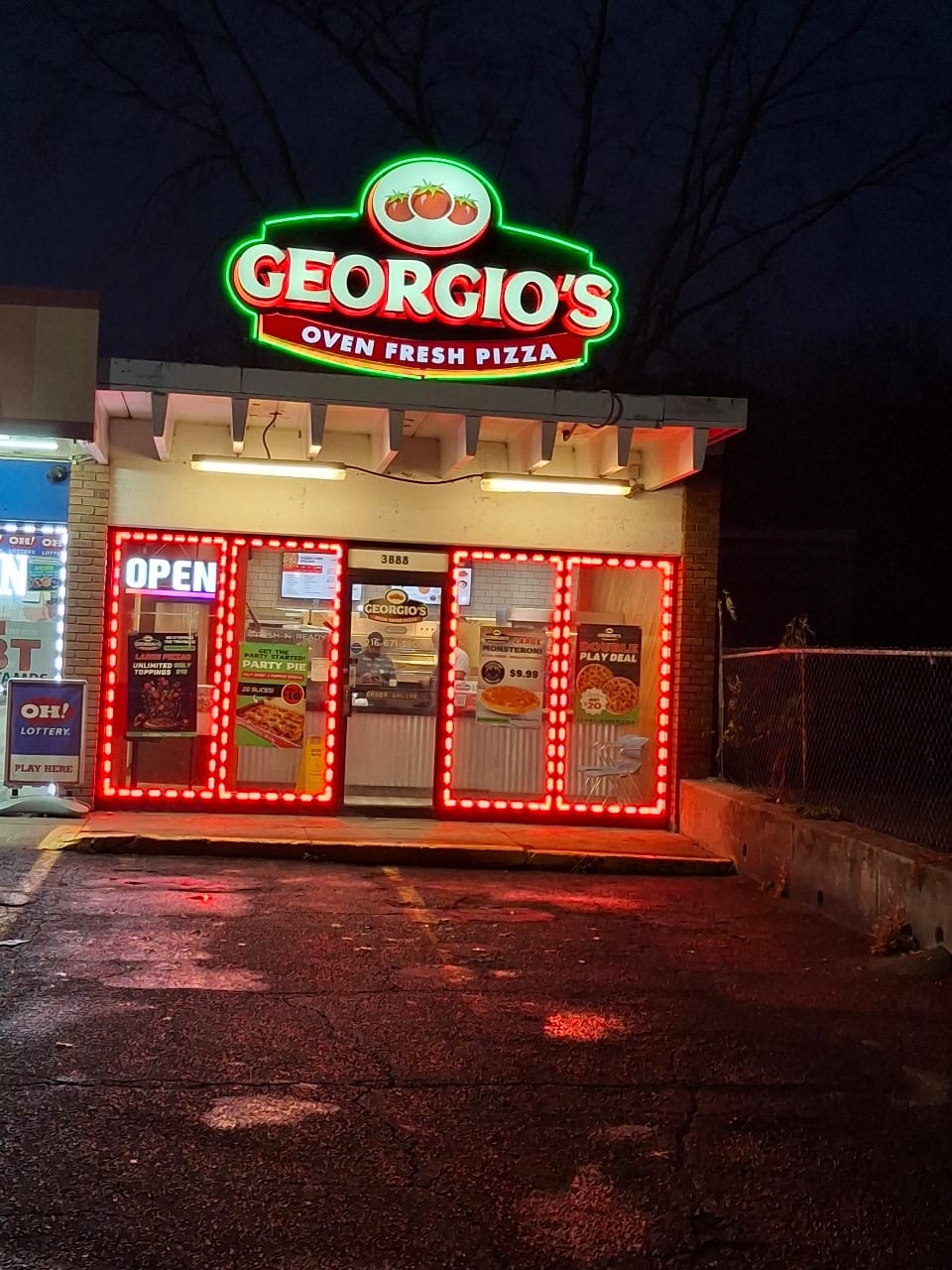 Georgio's Oven Fresh Pizza lit cabinet sign above a storefront ringed with red LED lights